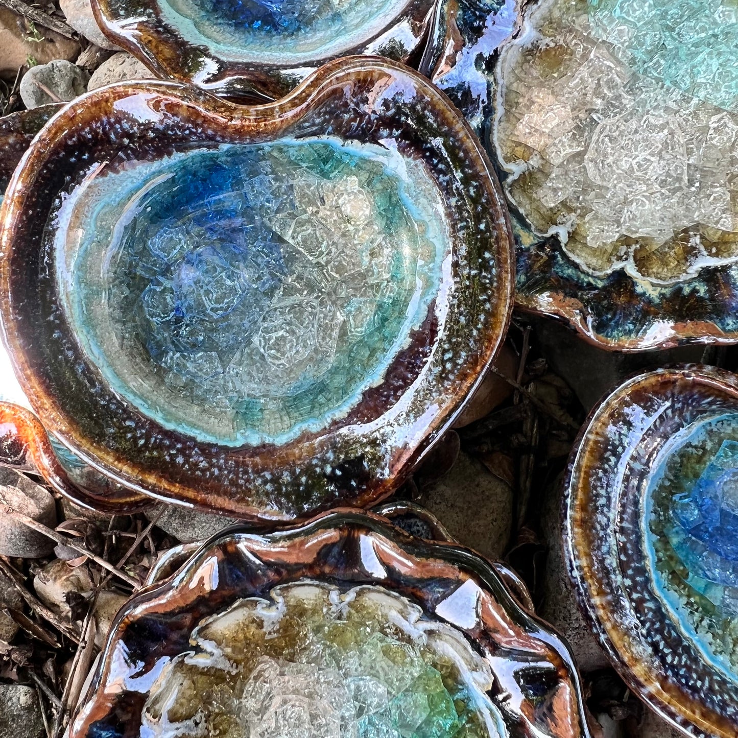 heart blues and browns crackled glass little dish displayed with round crackled glass little dish on a bed of leaves and rocks