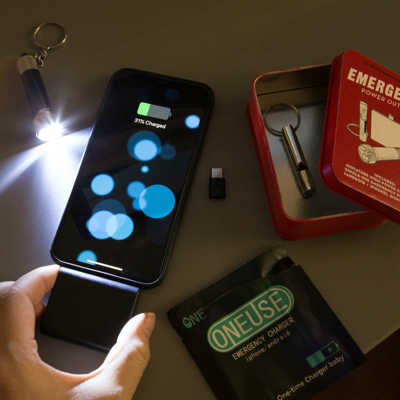 a person using the emergency power out kit next to a cell phone