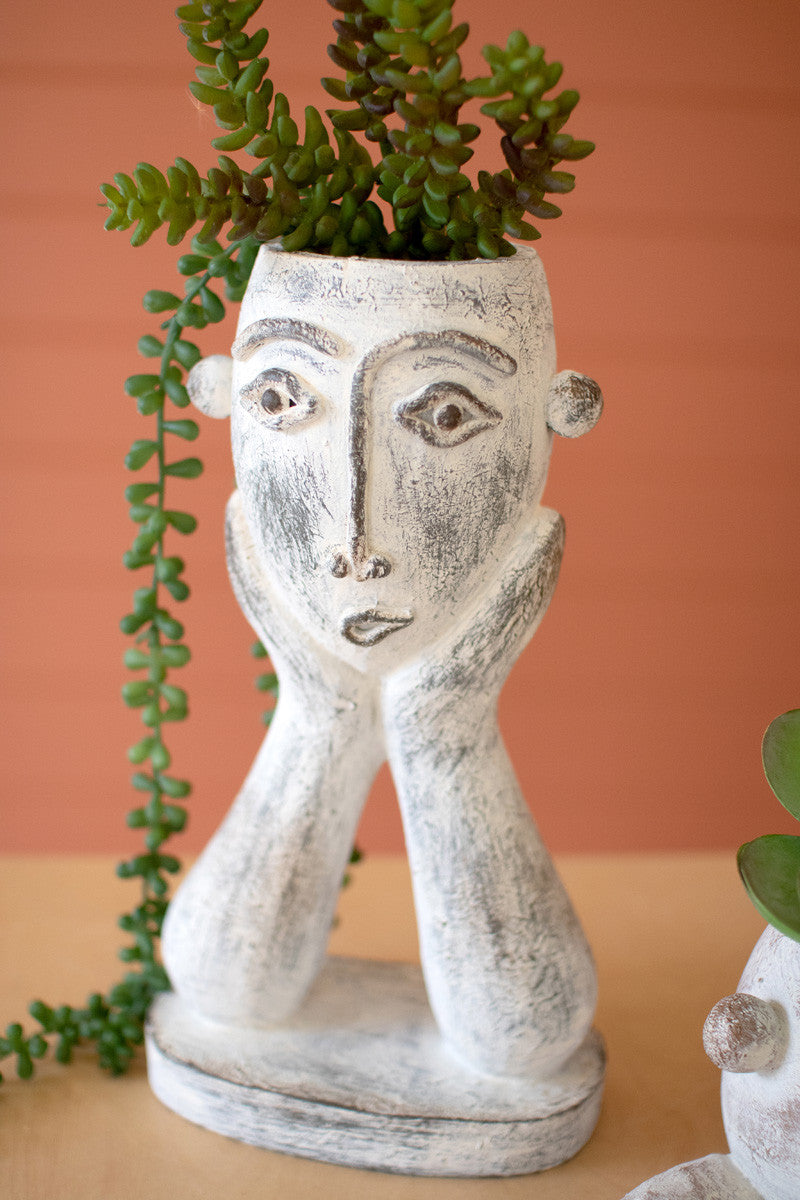 tall ceramic face planter filled with a succulent 