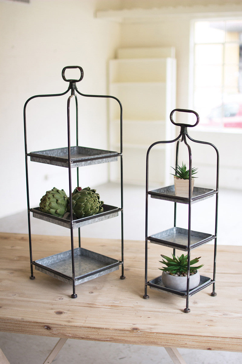 small and large metal stands with black frames and tin trays displayed on a light wood table
