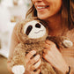person holding sloth plush toy.