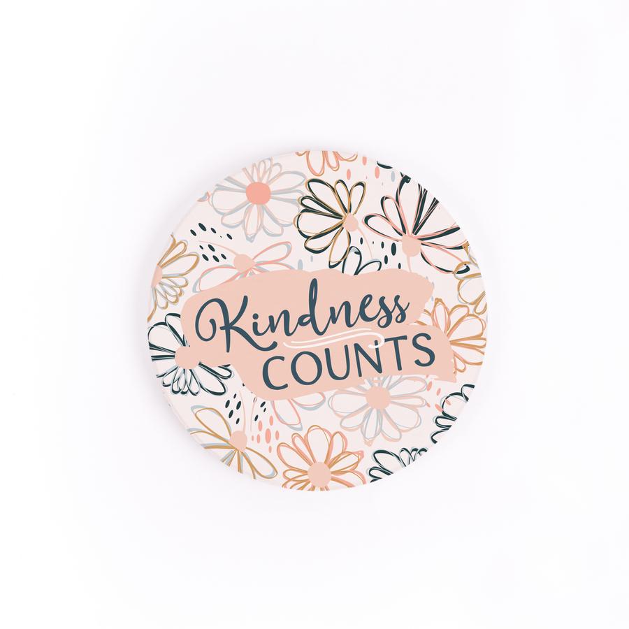 kindness counts car coaster is white with flowers outlined all over with text in navy blue displayed on a white background