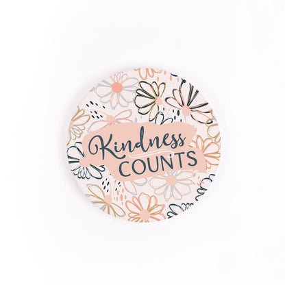 kindness counts car coaster is white with flowers outlined all over with text in navy blue displayed on a white background