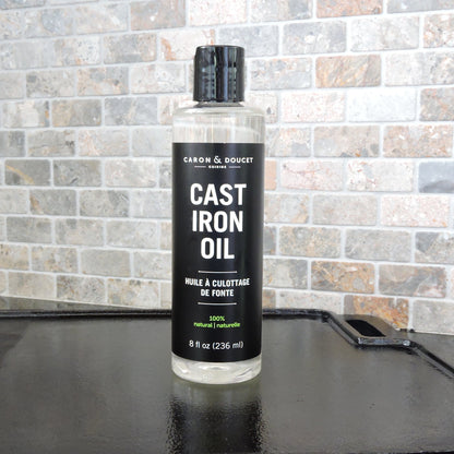 the cast iron seasoning oil displayed on a flat cast iron in a kitchen