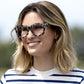 angled view of a woman standing outside wearing the gray tortoise center stage glasses