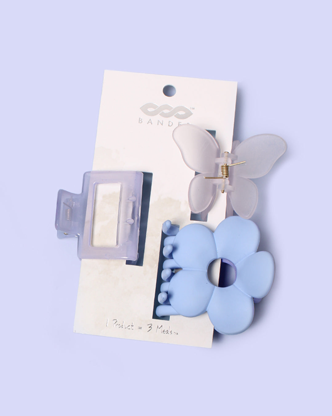 set of three purple and clear claw clips displayed on a white hanging card against a pale purple background