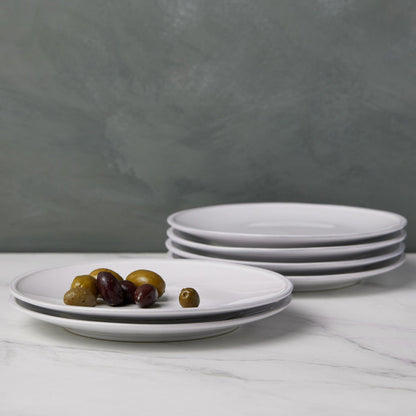2 stacks of white salad plates, short stack has olives on it.