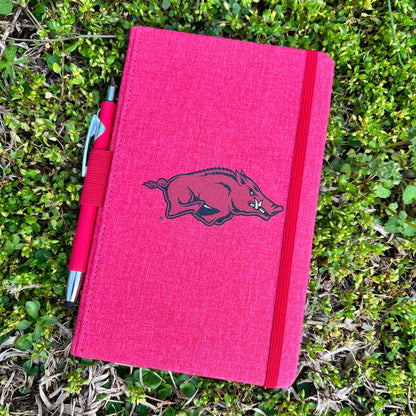 red journal with razorback logo in the center and red pen  and an elastic loop along the side to keep it closed.