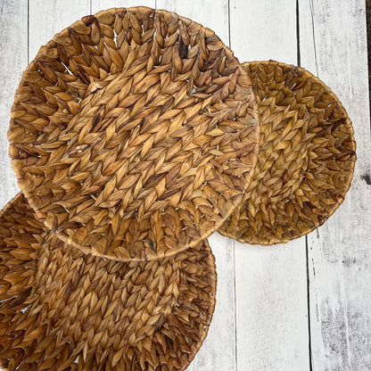 top view of 3 sizes of hyacinth baskets on a white wooden background.