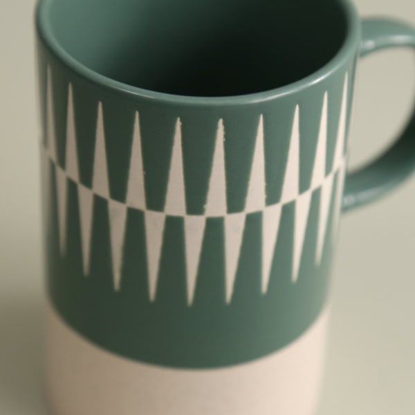 close-up of jade green mug with diamond pattern.