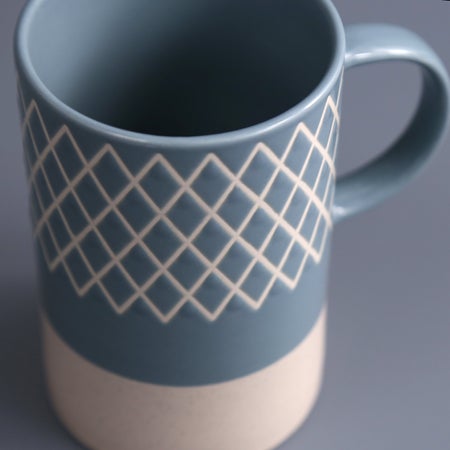 close-up of blue mug with criss-cross line pattern.