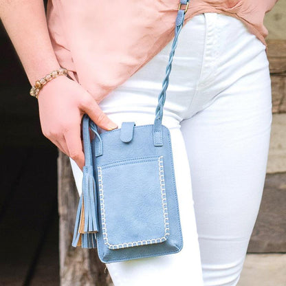 hip view of a woman modeling the bella blue free spirit purse while standing outside