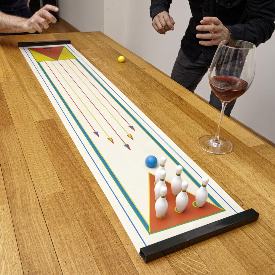 illustration of two people playing with the tabletop bowling on a kitchen table 