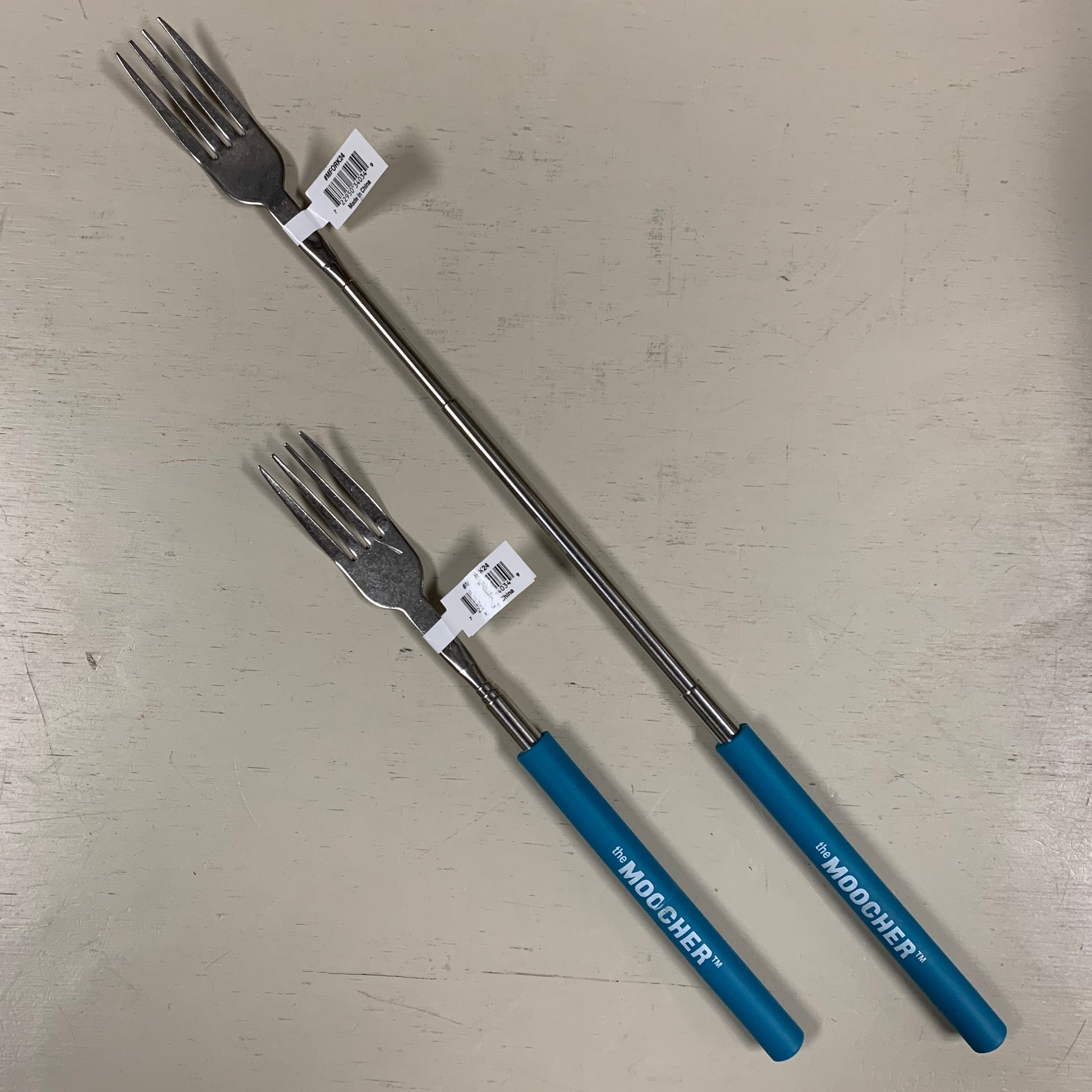 blue extendable forks displayed closed and opened and a light background