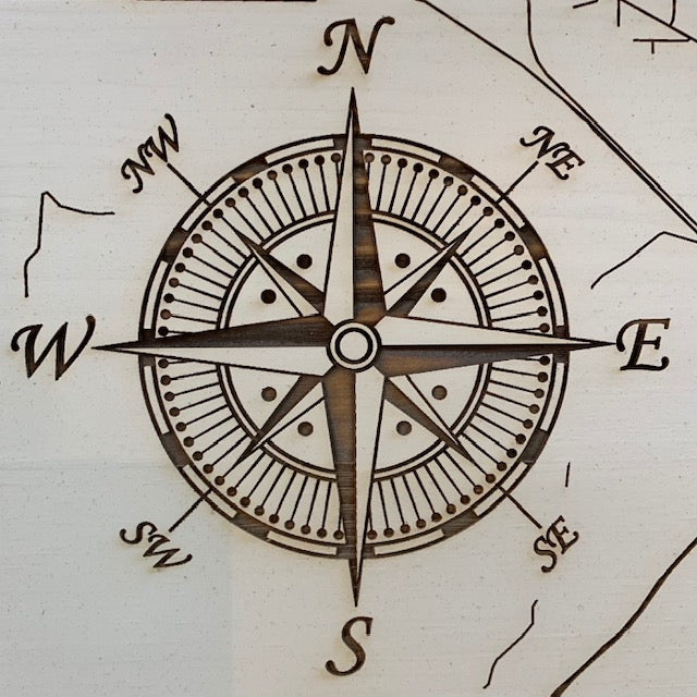 close up view of the compass rose on the ivory burnt wood map of conway