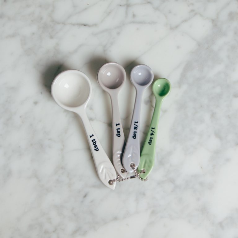 ceramic measuring spoons on marble countertop.