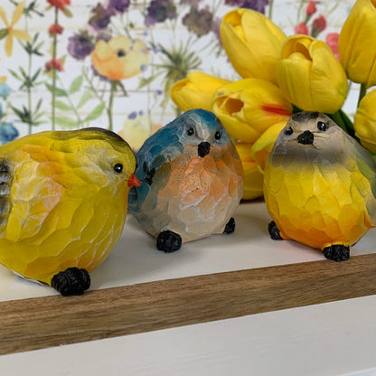 close up view of all three colorful birds displayed against a floral picture