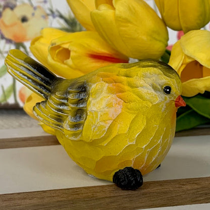 side view of the yellow bird sitter displayed next to yellow tulips