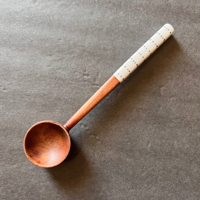dots handle wooden spoon on a gray background