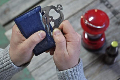 hands putting PocketMonkey tool in wallet.