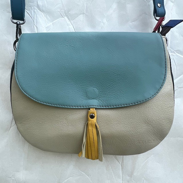 rounded grey purse with teal flap, yellow tassel, and blue strap.