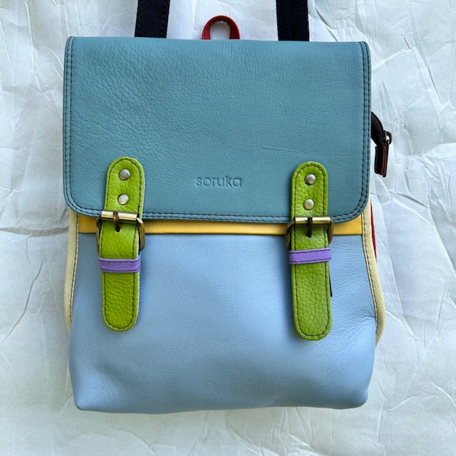 Light blue backpack with blue flap, green buckles, and yellow trim.