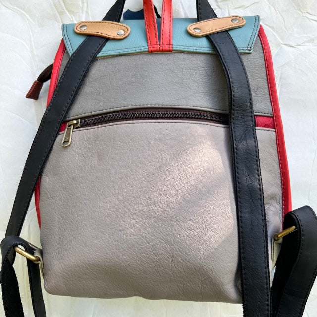 taupe back of backpack with side zipper and black straps.