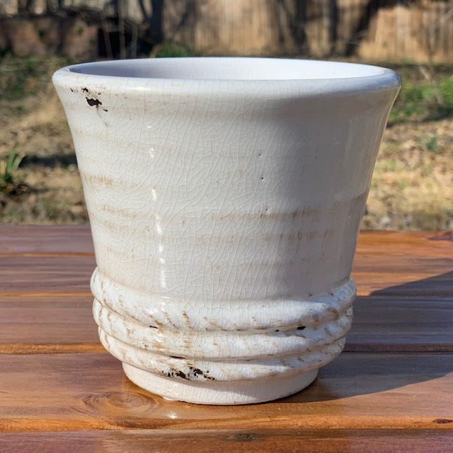 flared glazed ceramic pot displayed on a wooden picnic table outside
