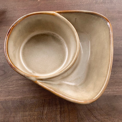taupe stoneware cracker and soup bowl on a dark stained wood surface