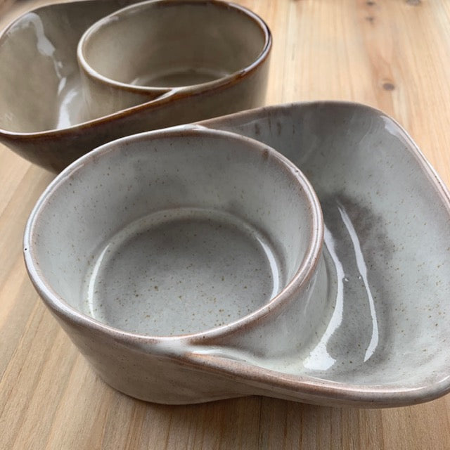 cream and taupe stoneware cracker and soup bowls on a light wood surface