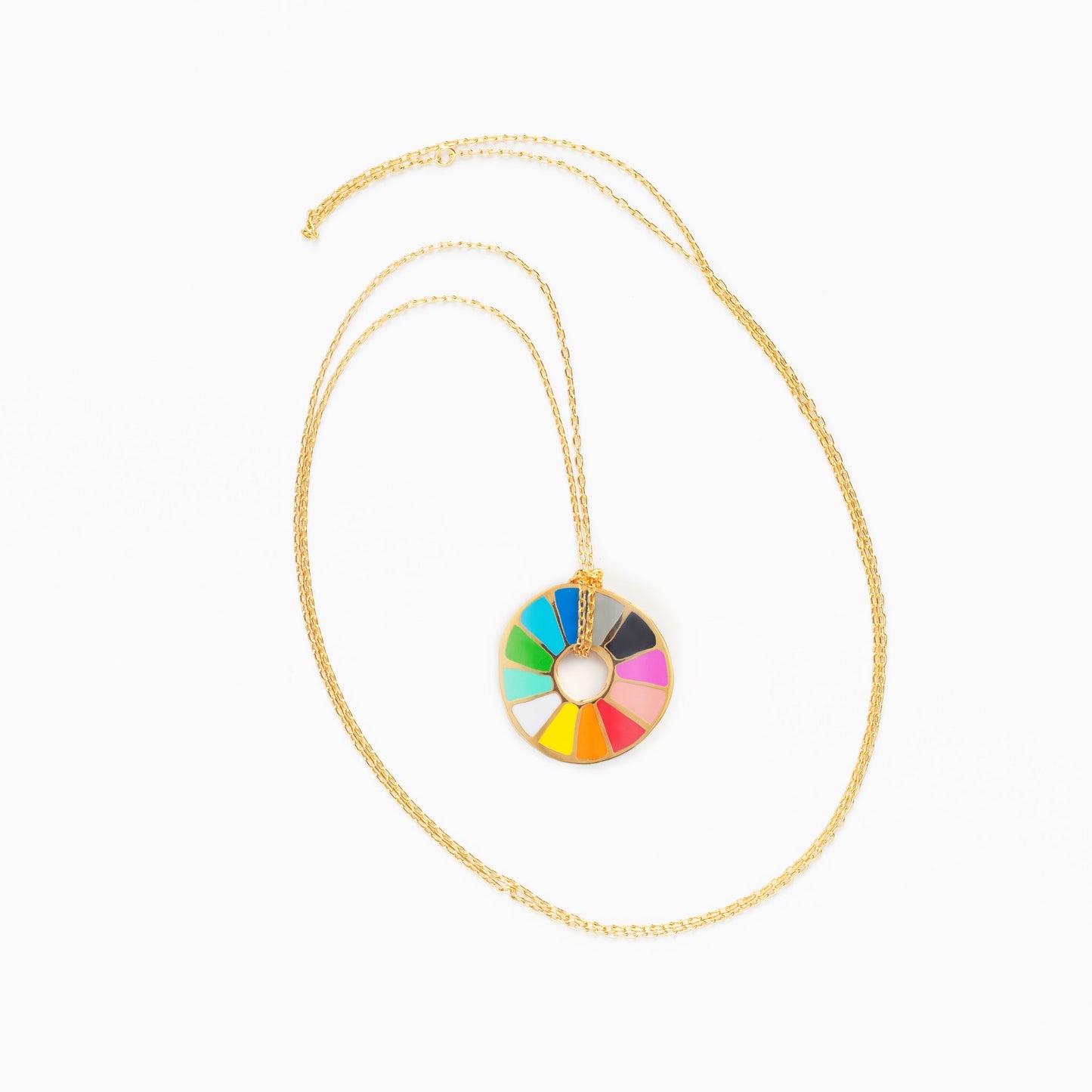 color wheel pendant on gold chain on white background.