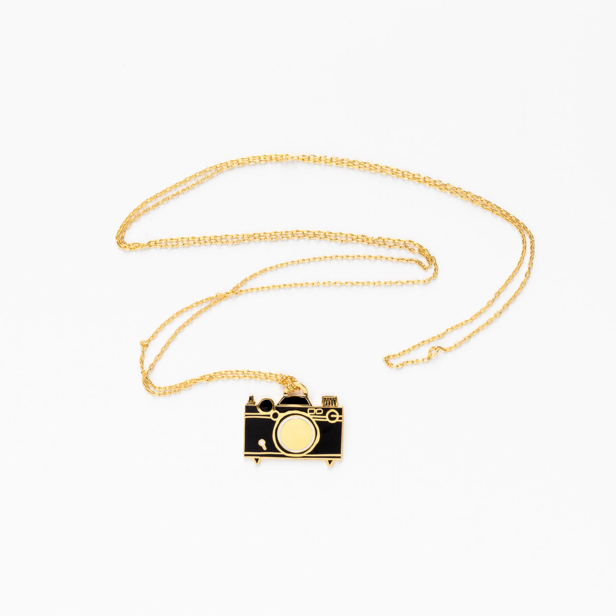 camera pendant on gold chain on white background.