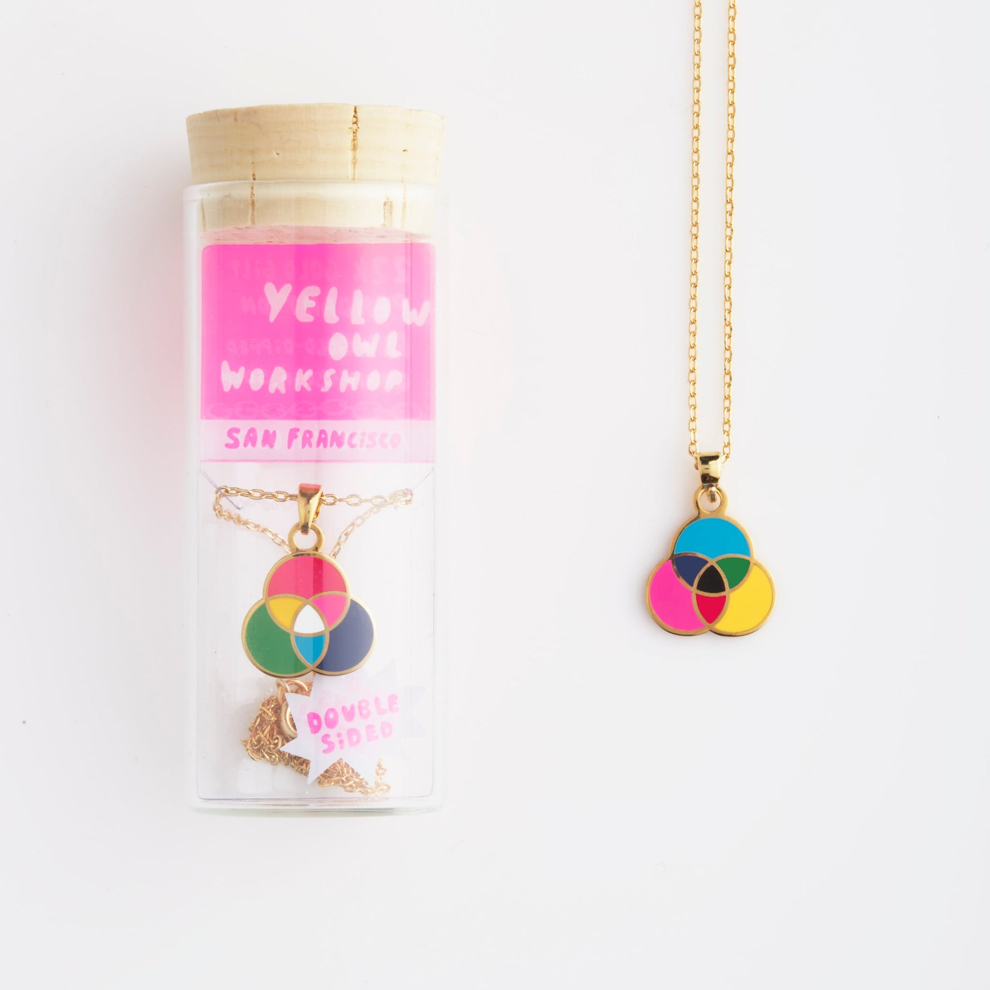 necklace shown in glass vile packaging on white background.