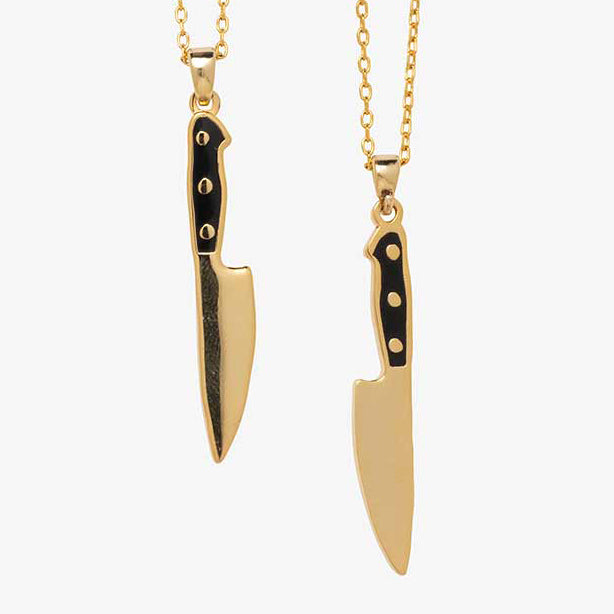 knife pendants hang on gold chain on white background.