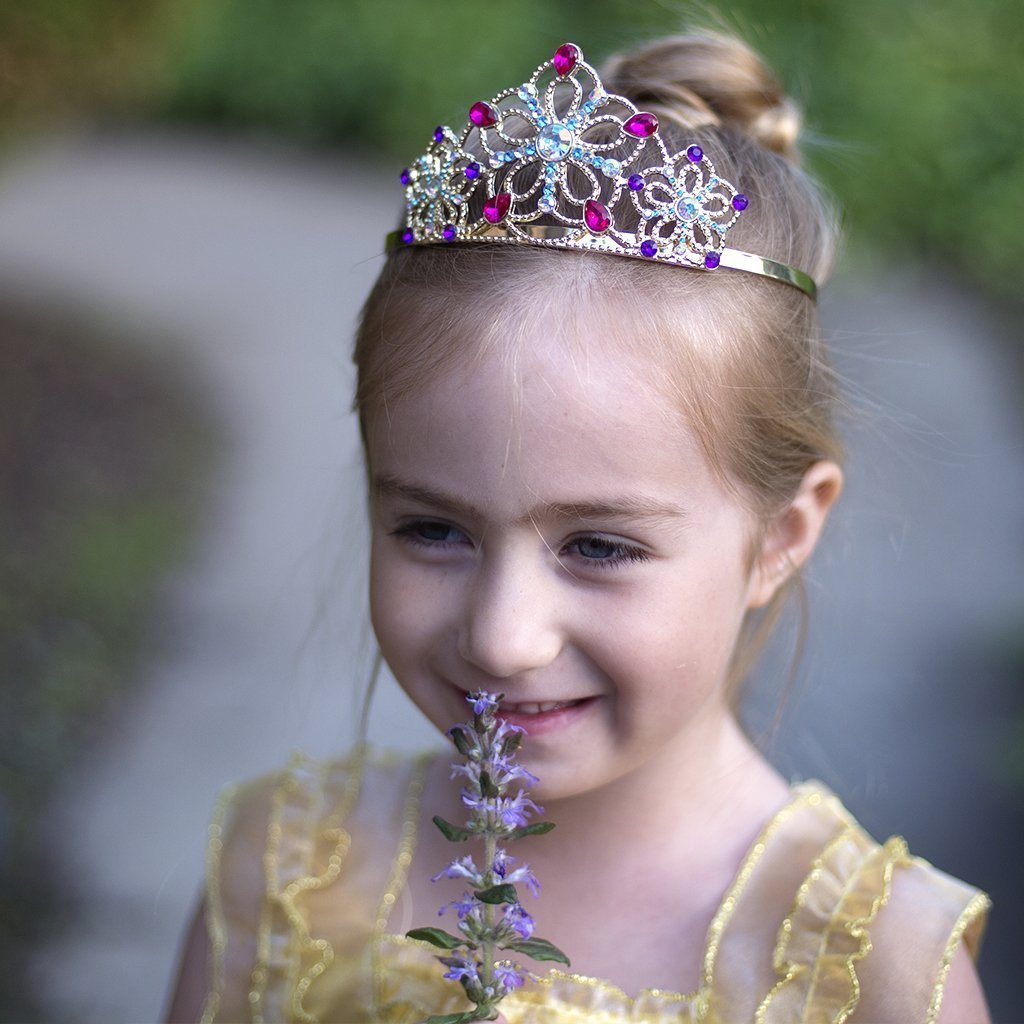a young girl wearing the bejeweled tiara while outdoors 
