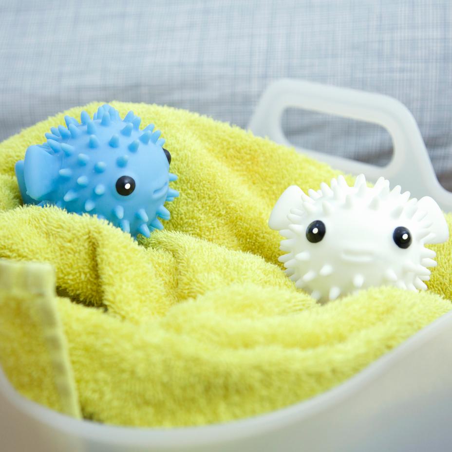 white and blue puffer fish dryer buddies displayed on a yellow towel in a basket