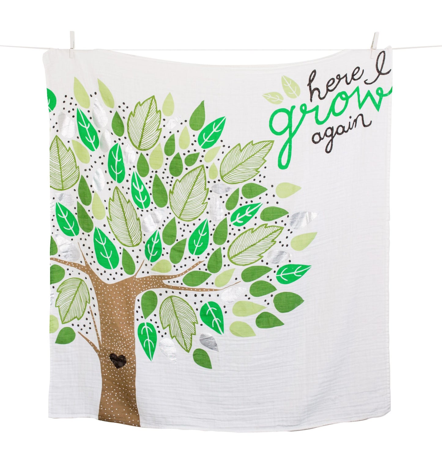 here i grow again milestone blanket hanging on a close line against a white background