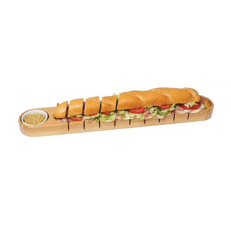 bamboo bread board and bowl with a sliced sandwich on a white background