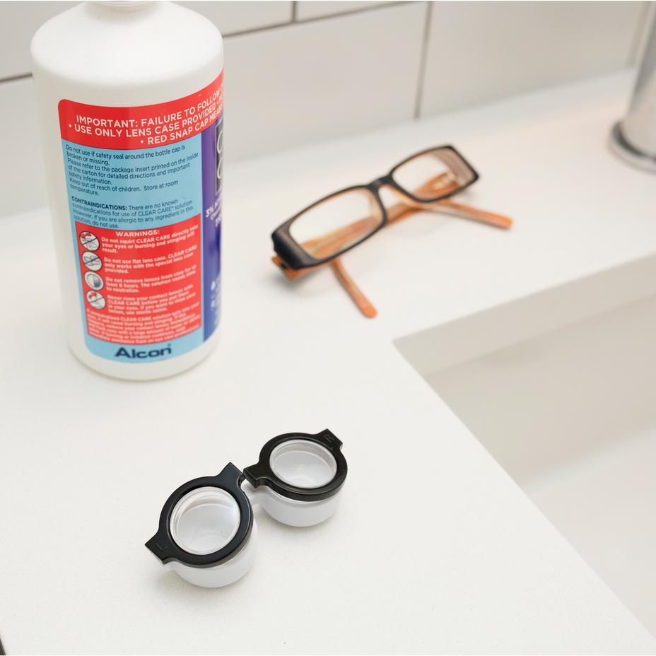 glasses shaped contact lens holder on a bathroom counter