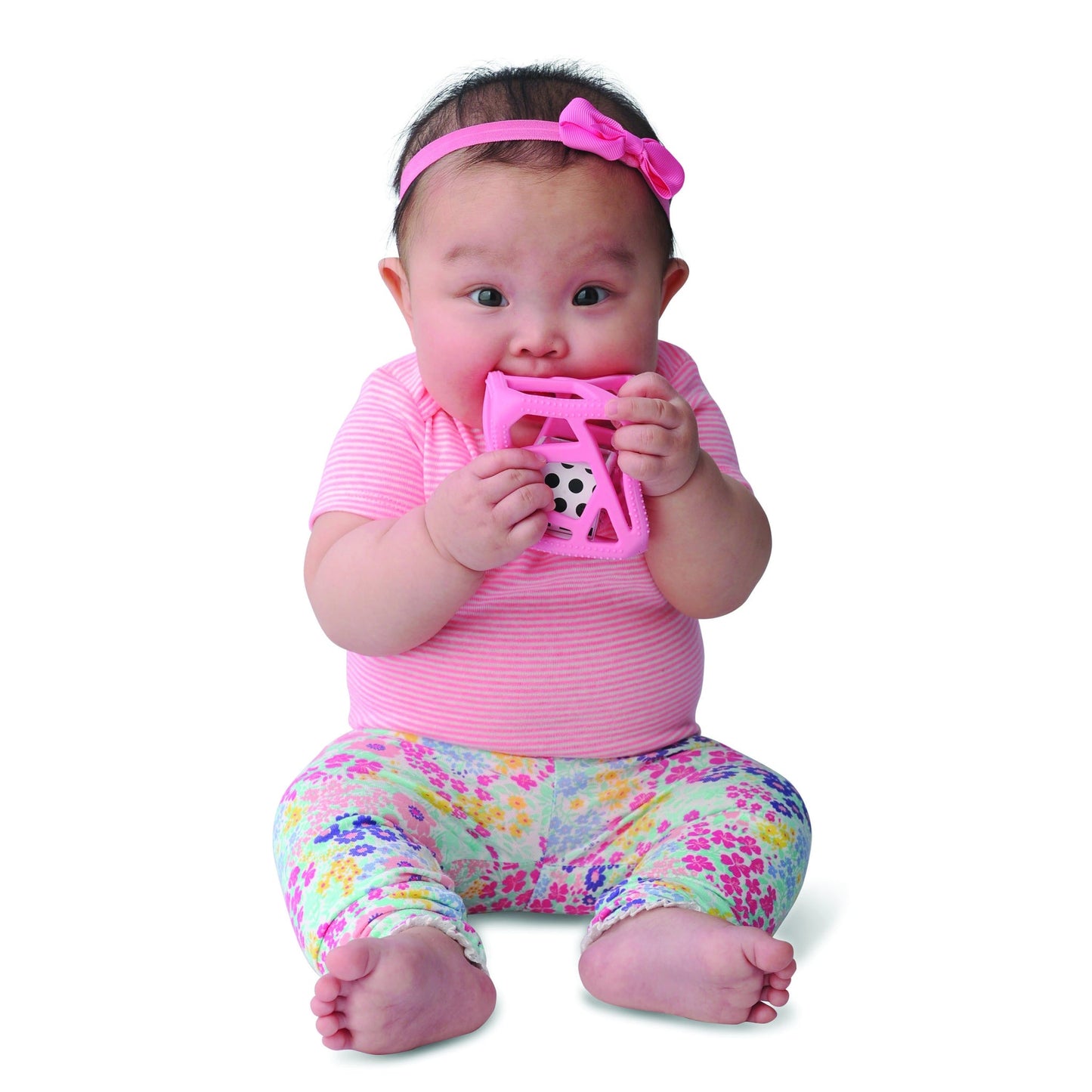 a little girls chewing on the pink chew cube against a white background