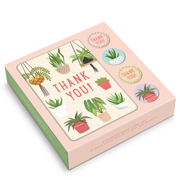 box of notecards on white background. box has blush pink background with graphics of house plants surrounding the words "thank you" in the center.