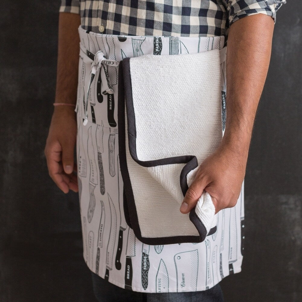 person wearing apron with oven towel tucked into apron ties.