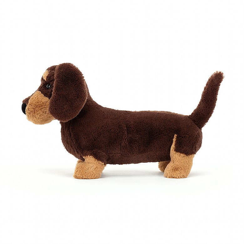 side view of otto sausage dog plush toy is brown and tan displayed against a white background