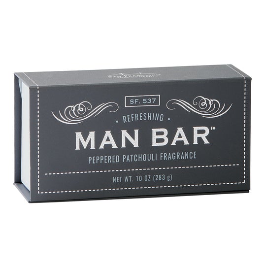 grey rectangular box of soap on white background. box has "man bar" written in gold, swirling gold graphics above text, and gold dotted line bordering the box edges.
