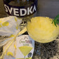 lemon drop slushie displayed in a glass next to the package and a bottle of vodka on a granite countertop