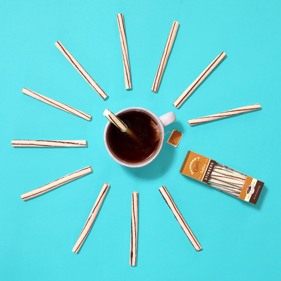 the toffee stirrers displayed around a cup of coffee on a turquoise background