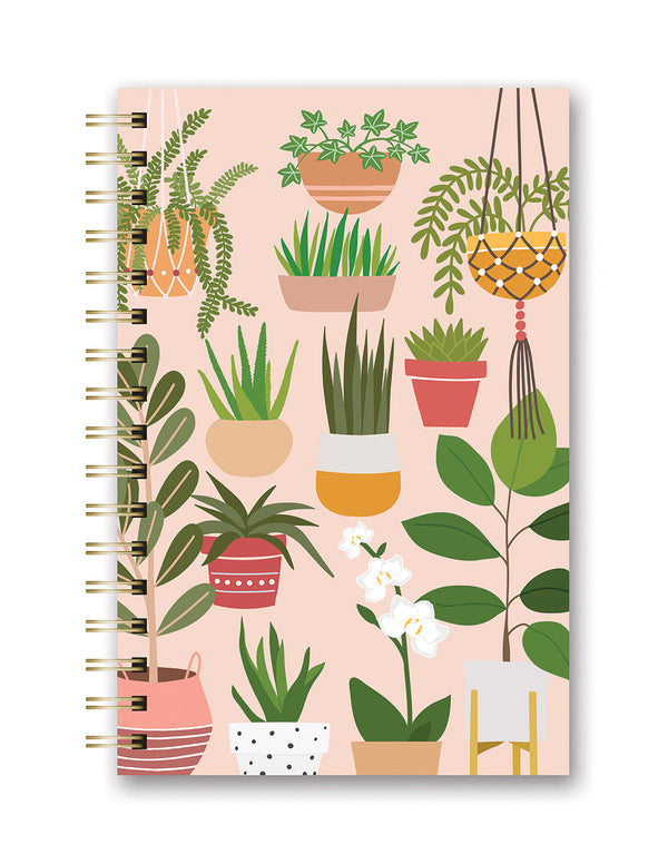 spiral notebook on white background. notebook cover has blush pink background with assorted graphics of house plants in pink, blush, white, and yellow pots.
