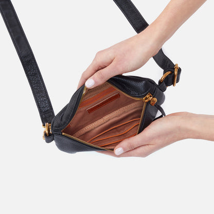 hands holding open black fern bag showing interior zip pockets and slip pockets.