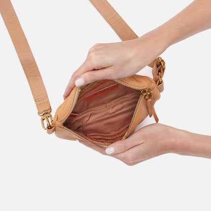 hands holding open sandstorm fern bag showing interior zip pockets and slip pockets.