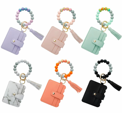 6 colorful bracelets with a wallet attached to them arranged on a white background.